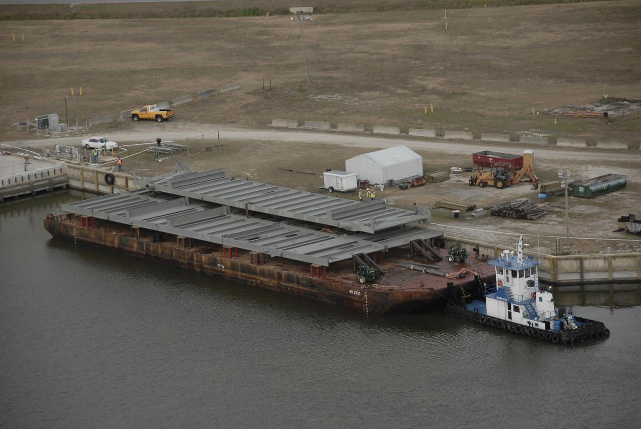 CAPE CANAVERAL, Fla. – Trestles and girders for a new mobile launcher arrive by barge at the turn basin in the Launch Complex 39 Area of NASA's Kennedy Space Center in Florida. The new launcher will be the base for the Constellation Program's Ares rockets to launch the Orion crew exploration vehicle and the cargo vehicle. The base is being made lighter than space shuttle mobile launcher platforms so the crawler-transporter can pick up the added load of the 345-foot tower and taller rocket. When the structural portion of the new mobile launcher is complete, umbilicals, access arms, communications equipment and command/control equipment will be installed. Photo credit: NASA/Kim Shiflett