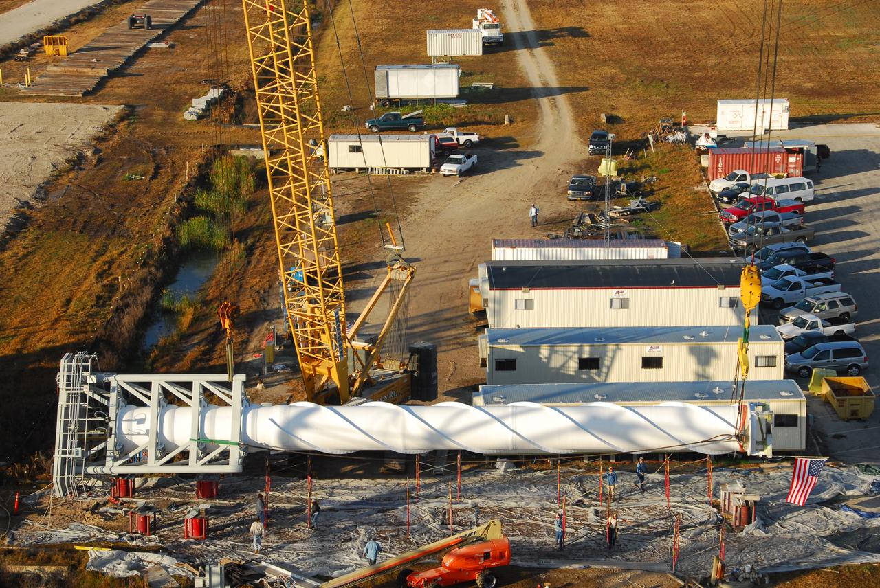 CAPE CANAVERAL, Fla. – On Launch Pad 39B at NASA's Kennedy Space Center in Florida, the 100-foot lightning mast is lifted off the ground.  It will be installed on top of the third and final new lightning tower being erected around the pad. The new lightning protection system is being built for the Constellation Program and Ares/Orion launches.  Each of the towers is 500 feet tall with an additional 100-foot fiberglass mast atop supporting a wire catenary system.  This improved lightning protection system allows for the taller height of the Ares I rocket compared to the space shuttle.  Pad 39B will be the site of the first Ares vehicle launch, including the Ares I-X test flight that is targeted for July 2009. Photo credit: NASA/Tim Jacobs