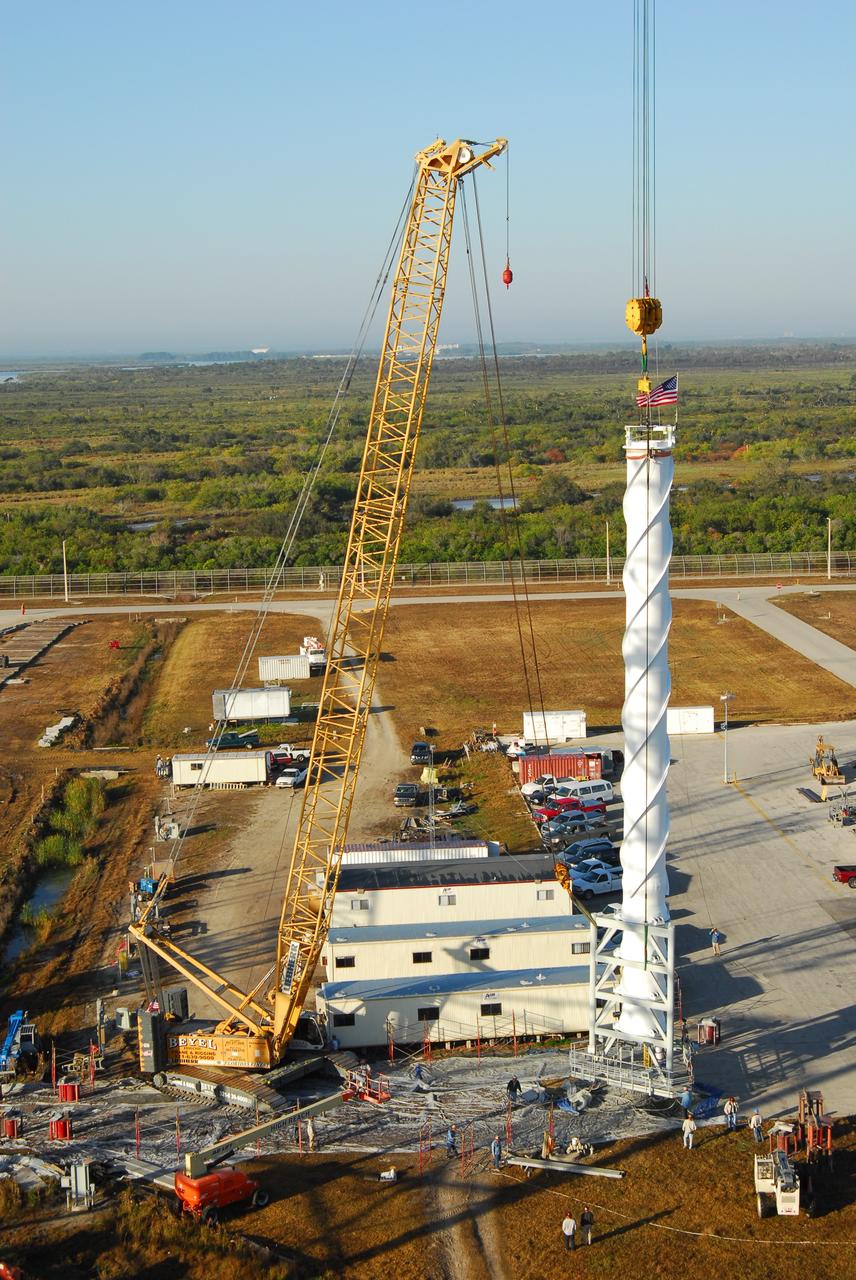 CAPE CANAVERAL, Fla. – On Launch Pad 39B at NASA's Kennedy Space Center in Florida, the 100-foot lightning mast has been raised to vertical.  It will be lifted and installed on top of the third and final new lightning tower being erected around the pad.  The new lightning protection system is being built for the Constellation Program and Ares/Orion launches.  Each of the towers is 500 feet tall with an additional 100-foot fiberglass mast atop supporting a wire catenary system.  This improved lightning protection system allows for the taller height of the Ares I rocket compared to the space shuttle.  Pad 39B will be the site of the first Ares vehicle launch, including the Ares I-X test flight that is targeted for July 2009. Photo credit: NASA/Tim Jacobs