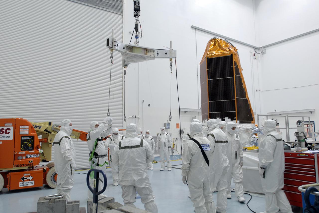 CAPE CANAVERAL, Fla. – At the Hazardous Processing Facility at Astrotech in Titusville, Fla., workers prepare the crane and scale that will be used to weigh the Kepler spacecraft, in the background at right. Kepler is designed to survey more than 100,000 stars in our galaxy to determine the number of sun-like stars that have Earth-size and larger planets, including those that lie in a star's "habitable zone," a region where liquid water, and perhaps life, could exist. If these Earth-size worlds do exist around stars like our sun, Kepler is expected to be the first to find them and the first to measure how common they are. The liftoff of Kepler aboard a Delta II rocket is currently targeted for 10:48 p.m. EST March 5 from Space Launch Complex 17 on Cape Canaveral Air Force Station. Photo credit: NASA/Jim Grossmann