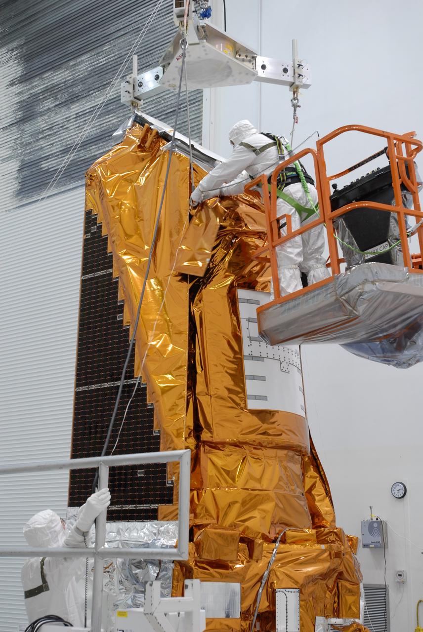 CAPE CANAVERAL, Fla. – At the Hazardous Processing Facility at Astrotech in Titusville, Fla., workers attach cables from the overhead crane onto the Kepler spacecraft. The crane will lift and weigh the spacecraft. Kepler is designed to survey more than 100,000 stars in our galaxy to determine the number of sun-like stars that have Earth-size and larger planets, including those that lie in a star's "habitable zone," a region where liquid water, and perhaps life, could exist. If these Earth-size worlds do exist around stars like our sun, Kepler is expected to be the first to find them and the first to measure how common they are. The liftoff of Kepler aboard a Delta II rocket is currently targeted for 10:48 p.m. EST March 5 from Space Launch Complex 17 on Cape Canaveral Air Force Station. Photo credit: NASA/Jim Grossmann