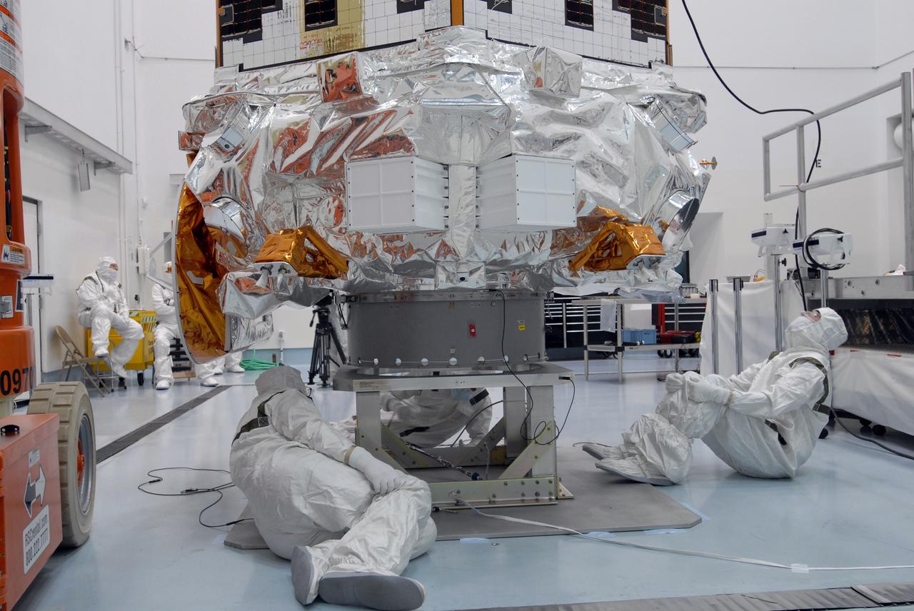 CAPE CANAVERAL, Fla. – At the Hazardous Processing Facility at Astrotech in Titusville, Fla., workers check the Kepler spacecraft as it is lifted for weighing. Kepler is designed to survey more than 100,000 stars in our galaxy to determine the number of sun-like stars that have Earth-size and larger planets, including those that lie in a star's "habitable zone," a region where liquid water, and perhaps life, could exist. If these Earth-size worlds do exist around stars like our sun, Kepler is expected to be the first to find them and the first to measure how common they are. The liftoff of Kepler aboard a Delta II rocket is currently targeted for 10:48 p.m. EST March 5 from Space Launch Complex 17 on Cape Canaveral Air Force Station. Photo credit: NASA/Jim Grossmann