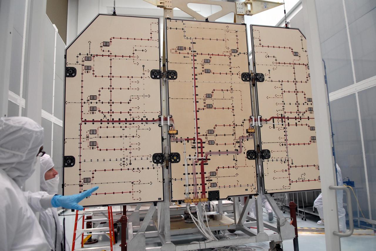 CAPE CANAVERAL, Fla. – Technicians inspect the solar arrays for NASA's Lunar Reconnaissance Orbiter, or LRO, at the Astrotech processing facility in Titusville, Fla.  The spacecraft was built by engineers at Goddard Space Flight Center, where it recently completed two months of tests in a thermal vacuum chamber. The orbiter will carry seven instruments to provide scientists with detailed maps of the lunar surface and enhance our understanding of the moon's topography, lighting conditions, mineralogical composition and natural resources. Information gleaned from LRO will be used to select safe landing sites, determine locations for future lunar outposts and help mitigate radiation dangers to astronauts. The polar regions of the moon are the main focus of the mission because continuous access to sunlight may be possible and water ice may exist in permanently shadowed areas of the poles. Accompanying LRO on its journey to the moon will be the Lunar Crater Observation and Sensing Satellite, or LCROSS, a mission that will impact the lunar surface in its search for water ice. Launch of LRO/LCROSS is targeted for April 24.     Photo credit: NASA/Jack Pfaller