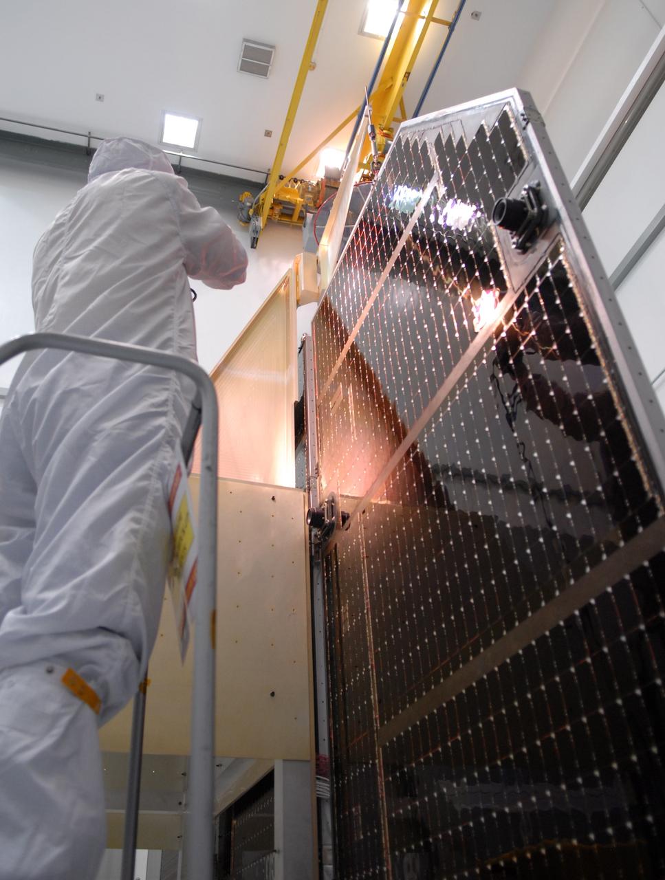 CAPE CANAVERAL, Fla. – A technician inspects the solar arrays for NASA's Lunar Reconnaissance Orbiter, or LRO, at the Astrotech processing facility in Titusville, Fla.  The spacecraft was built by engineers at Goddard Space Flight Center, where it recently completed two months of tests in a thermal vacuum chamber. The orbiter will carry seven instruments to provide scientists with detailed maps of the lunar surface and enhance our understanding of the moon's topography, lighting conditions, mineralogical composition and natural resources. Information gleaned from LRO will be used to select safe landing sites, determine locations for future lunar outposts and help mitigate radiation dangers to astronauts. The polar regions of the moon are the main focus of the mission because continuous access to sunlight may be possible and water ice may exist in permanently shadowed areas of the poles. Accompanying LRO on its journey to the moon will be the Lunar Crater Observation and Sensing Satellite, or LCROSS, a mission that will impact the lunar surface in its search for water ice. Launch of LRO/LCROSS is targeted for April 24.     Photo credit: NASA/Jack Pfaller