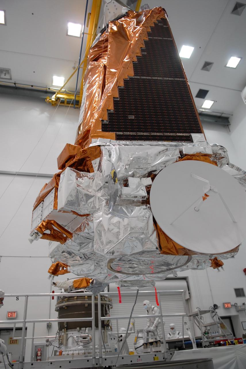 CAPE CANAVERAL, Fla. – At the Hazardous Processing Facility at Astrotech in Titusville, Fla., the Kepler spacecraft is lifted from a work stand to be joined to a Delta II third stage, in the background. Kepler is designed to survey more than 100,000 stars in our galaxy to determine the number of sun-like stars that have Earth-size and larger planets, including those that lie in a star's "habitable zone," a region where liquid water, and perhaps life, could exist. If these Earth-size worlds do exist around stars like our sun, Kepler is expected to be the first to find them and the first to measure how common they are. The liftoff of Kepler aboard a Delta II rocket is currently targeted for 10:48 p.m. EST March 5 from Space Launch Complex 17 on Cape Canaveral Air Force Station. Photo credit: NASA/Troy Cryder