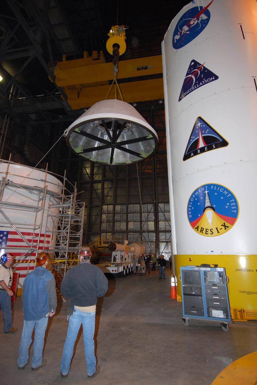 CAPE CANAVERAL, Fla. – In high bay 4 of the Vehicle Assembly Building at NASA's Kennedy Space Center, the Ares I-X crew module mock-up hangs suspended from a crane as it is moved for a fit check with a mock-up of the service module. When fully developed, the 16-foot diameter crew module will furnish living space and reentry protection for future astronauts, and the service module’s main engine will be used to break out of lunar orbit for the return trip to Earth.  Ares I-X is the test flight for the Ares I, which is part of the Constellation Program to return men to the moon and beyond. The I-X flight will provide NASA an early opportunity to test and prove hardware, facilities and ground operations associated with Ares I launches. Targeted for the summer of 2009, the launch of the full-scale Ares I-X will be the first in a series of unpiloted rocket launches from Kennedy.   Photo credit: NASA/Jack Pfaller