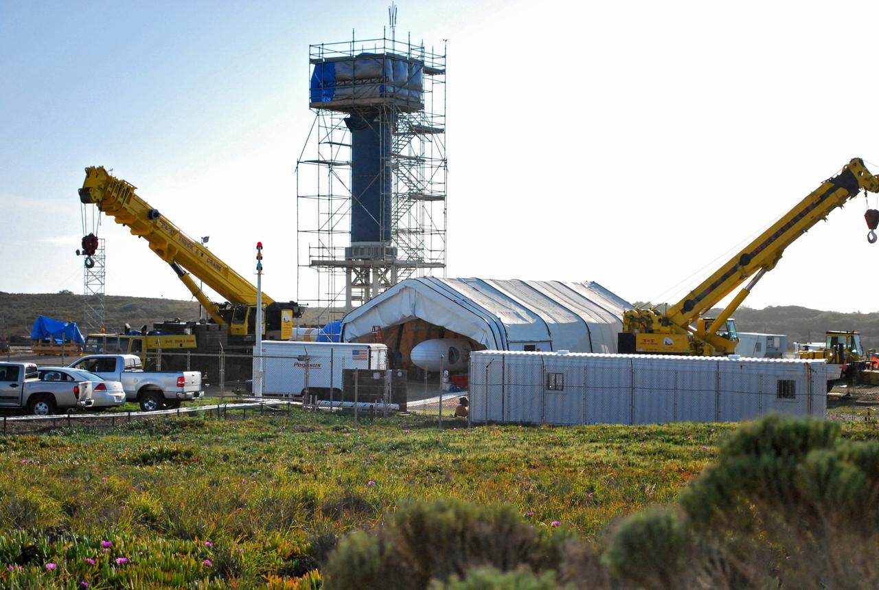 VANDENBERG AIR FORCE BASE, Calif. --  On Space Launch Complex 576-E at Vandenberg Air Force Base in California, cranes are in position to move the tent where the upper stage of Orbital Sciences' Taurus XL rocket is ready to be moved and lifted into the tower for stacking.  The spacecraft is scheduled for launch aboard Orbital Sciences' Taurus XL rocket Feb. 24 from Vandenberg. The spacecraft will collect precise global measurements of carbon dioxide (CO2) in the Earth's atmosphere. Scientists will analyze OCO data to improve our understanding of the natural processes and human activities that regulate the abundance and distribution of this important greenhouse gas.  Photo credit: NASA/Randy Beaudoin, VAFB