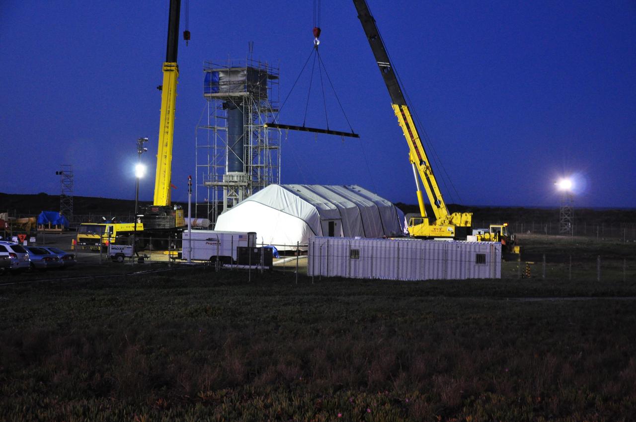 VANDENBERG AIR FORCE BASE, Calif. --  Just before dawn on Launch Complex 576-E at Vandenberg Air Force Base in California, a crane is attached to the tent covering NASA's Orbiting Carbon Observatory, or OCO, the Taurus XL upper stack and the umbilical tower.  The tent will be removed to allow OCO to be raised.  The spacecraft is scheduled for launch aboard Orbital Sciences' Taurus XL rocket Feb. 24 from Vandenberg. The spacecraft will collect precise global measurements of carbon dioxide (CO2) in the Earth's atmosphere. Scientists will analyze OCO data to improve our understanding of the natural processes and human activities that regulate the abundance and distribution of this important greenhouse gas.   Photo credit: NASA/Randy Beaudoin, VAFB