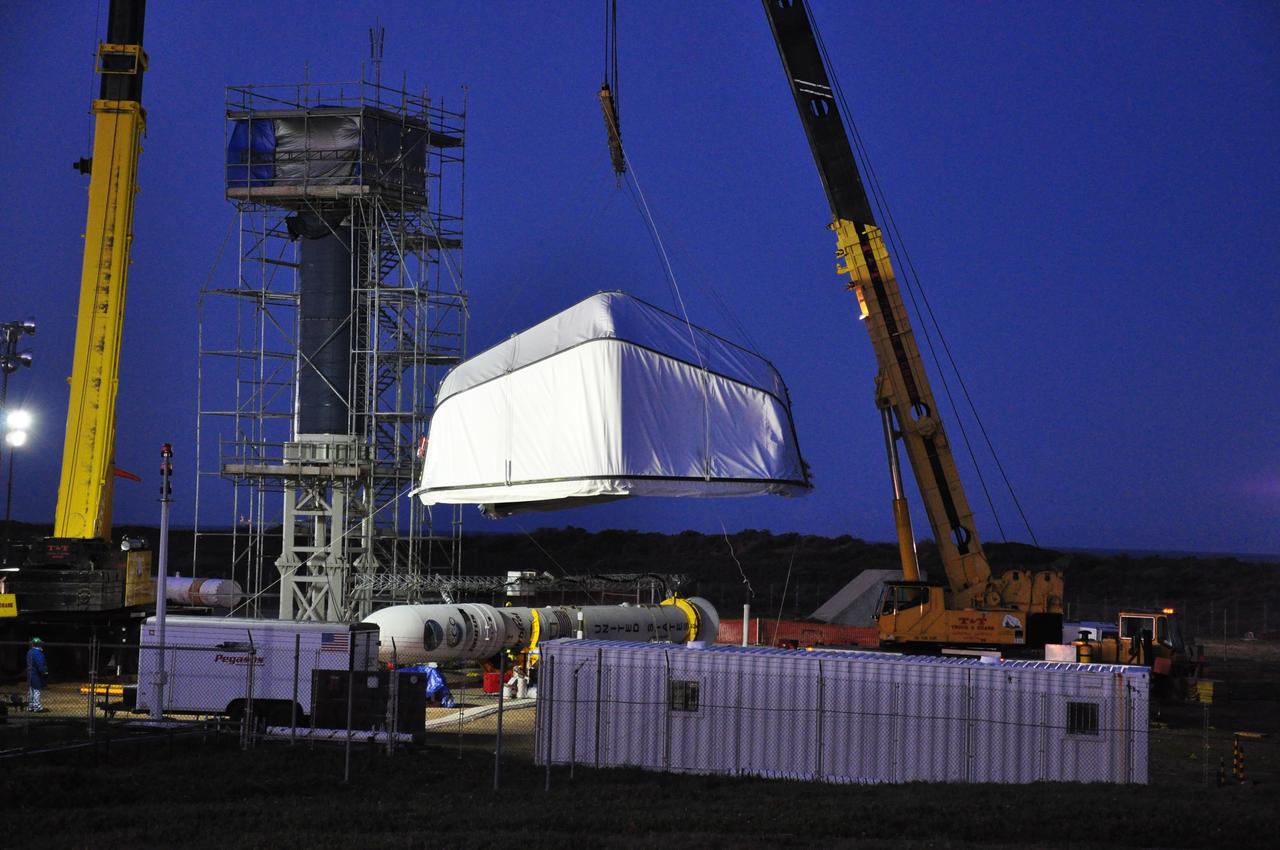 VANDENBERG AIR FORCE BASE, Calif. --  Just before dawn on Launch Complex 576-E at Vandenberg Air Force Base in California, a crane  lifts the tent covering (at left) NASA's Orbiting Carbon Observatory, or OCO, the Taurus XL upper stack and the umbilical tower.  The tent removal will allow OCO to be raised. The spacecraft is scheduled for launch aboard Orbital Sciences' Taurus XL rocket Feb. 24 from Vandenberg. The spacecraft will collect precise global measurements of carbon dioxide (CO2) in the Earth's atmosphere. Scientists will analyze OCO data to improve our understanding of the natural processes and human activities that regulate the abundance and distribution of this important greenhouse gas.   Photo credit: NASA/Randy Beaudoin, VAFB