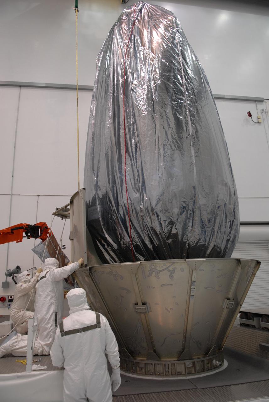 CAPE CANAVERAL, Fla. – At the Astrotech payload processing facility in Titusville, Fla., workers place the second row of canister segments around NASA's Kepler spacecraft. The "canning" provides protection during the spacecraft's transport to the pad. The liftoff of Kepler aboard a Delta II rocket is currently targeted for 10:48 p.m. EST March 5 from Pad 17-B. Kepler is designed to survey more than 100,000 stars in our galaxy to determine the number of sun-like stars that have Earth-size and larger planets, including those that lie in a star's "habitable zone," a region where liquid water, and perhaps life, could exist. If these Earth-size worlds do exist around stars like our sun, Kepler is expected to be the first to find them and the first to measure how common they are. Photo credit: NASA/Troy Cryder