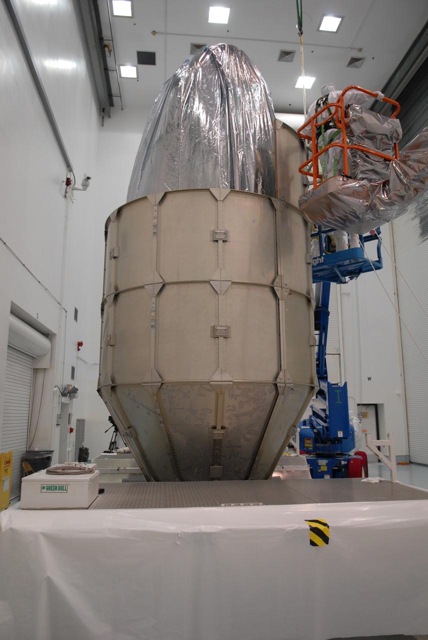 CAPE CANAVERAL, Fla. –  At the Astrotech payload processing facility in Titusville, Fla., another segment of the canister is added to the stack around NASA's Kepler spacecraft. The "canning" provides protection during the spacecraft's transport to the pad. The liftoff of Kepler aboard a Delta II rocket is currently targeted for 10:48 p.m. EST March 5 from Pad 17-B. Kepler is designed to survey more than 100,000 stars in our galaxy to determine the number of sun-like stars that have Earth-size and larger planets, including those that lie in a star's "habitable zone," a region where liquid water, and perhaps life, could exist. If these Earth-size worlds do exist around stars like our sun, Kepler is expected to be the first to find them and the first to measure how common they are. Photo credit: NASA/Troy Cryder