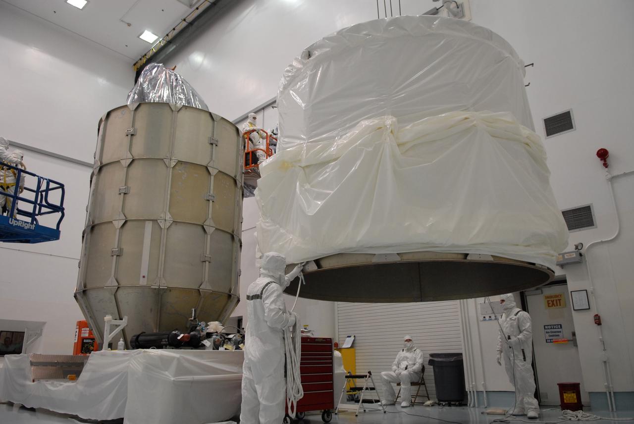 CAPE CANAVERAL, Fla. – At the Astrotech payload processing facility in Titusville, Fla., the top of the canister is lifted for a move to the unfinished canister at left. The canister surrounding NASA's Kepler spacecraft provides protection during the spacecraft's transport to the pad. The liftoff of Kepler aboard a Delta II rocket is currently targeted for 10:48 p.m. EST March 5 from Pad 17-B. Kepler is designed to survey more than 100,000 stars in our galaxy to determine the number of sun-like stars that have Earth-size and larger planets, including those that lie in a star's "habitable zone," a region where liquid water, and perhaps life, could exist. If these Earth-size worlds do exist around stars like our sun, Kepler is expected to be the first to find them and the first to measure how common they are. Photo credit: NASA/Troy Cryder