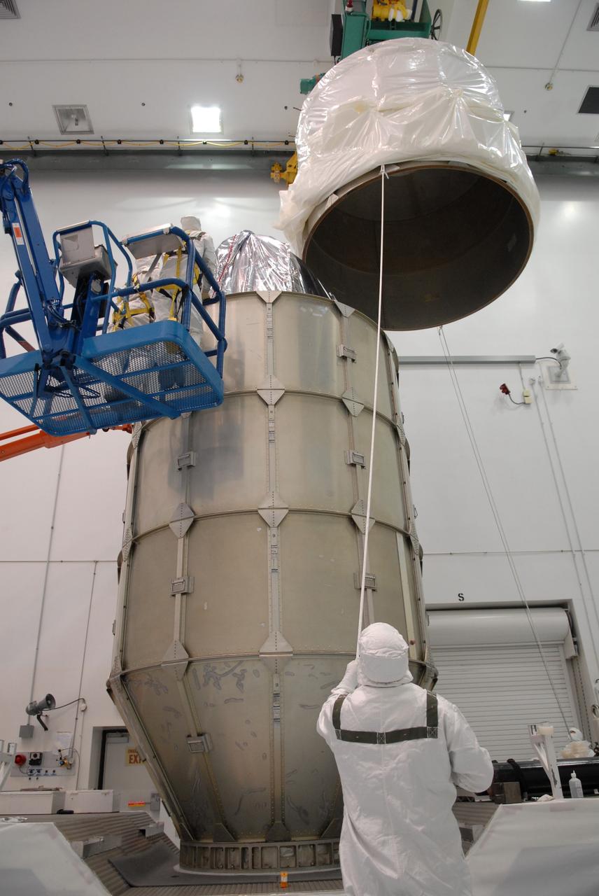 CAPE CANAVERAL, Fla. – At the Astrotech payload processing facility in Titusville, Fla., the top of the canister is lifted over NASA's Kepler spacecraft where it will be attached to the lower segments. The canister surrounding Kepler provides protection during the spacecraft's transport to the pad. The liftoff of Kepler aboard a Delta II rocket is currently targeted for 10:48 p.m. EST March 5 from Pad 17-B. Kepler is designed to survey more than 100,000 stars in our galaxy to determine the number of sun-like stars that have Earth-size and larger planets, including those that lie in a star's "habitable zone," a region where liquid water, and perhaps life, could exist. If these Earth-size worlds do exist around stars like our sun, Kepler is expected to be the first to find them and the first to measure how common they are. Photo credit: NASA/Troy Cryder