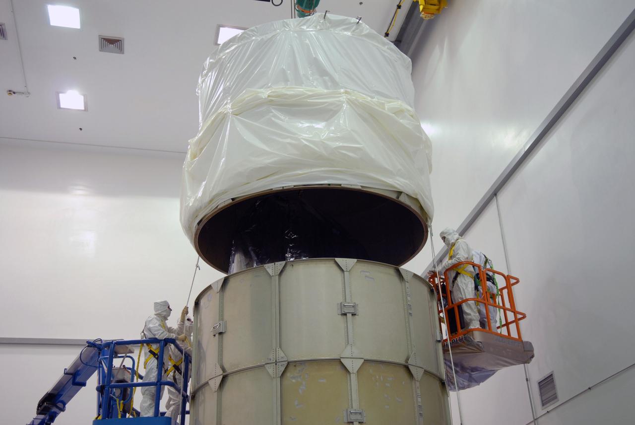 CAPE CANAVERAL, Fla. – At the Astrotech payload processing facility in Titusville, Fla., the top of the canister is lowered over NASA's Kepler spacecraft where it will be attached to the lower segments. The canister surrounding Kepler provides protection during the spacecraft's transport to the pad. The liftoff of Kepler aboard a Delta II rocket is currently targeted for 10:48 p.m. EST March 5 from Pad 17-B. Kepler is designed to survey more than 100,000 stars in our galaxy to determine the number of sun-like stars that have Earth-size and larger planets, including those that lie in a star's "habitable zone," a region where liquid water, and perhaps life, could exist. If these Earth-size worlds do exist around stars like our sun, Kepler is expected to be the first to find them and the first to measure how common they are. Photo credit: NASA/Troy Cryder