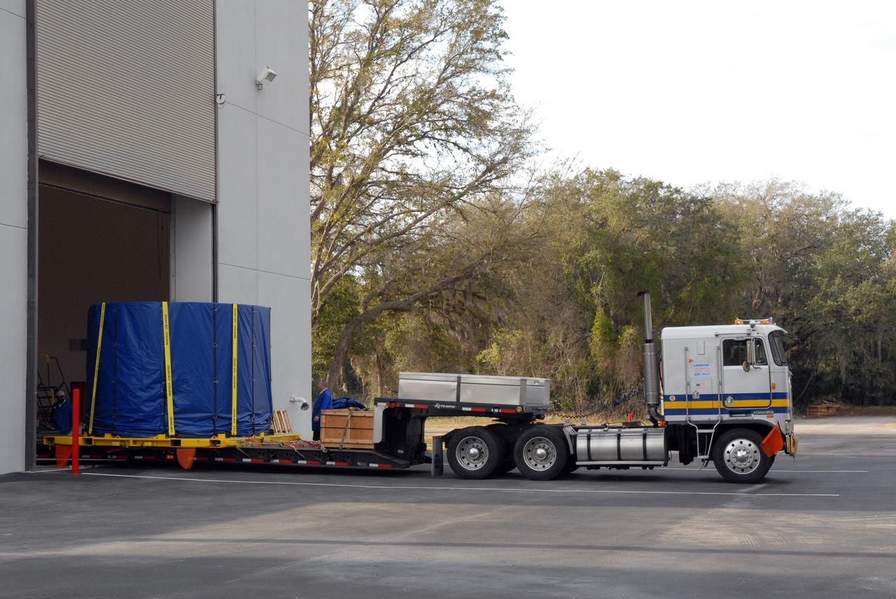 CAPE CANAVERAL, Fla. – The covered fifth segment simulator center for the Ares I-X rocket leaves Astrotech in Titusville, Fla., heading for the Vehicle Assembly Building at NASA's Kennedy Space Center in Florida. It will join other segments being stacked there. Ares I-X is the test vehicle for the Ares I, which is part of the Constellation Program to return men to the moon and beyond. Ares I is the essential core of a safe, reliable, cost-effective space transportation system that eventually will carry crewed missions back to the moon, on to Mars and out into the solar system. Ares I-X is targeted for launch in July 2009. Photo credit: NASA/Troy Cryder