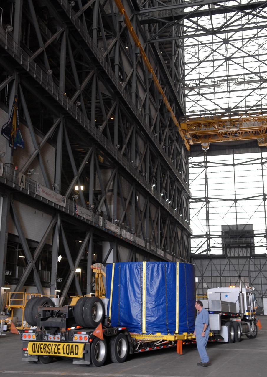 CAPE CANAVERAL, Fla. – The covered fifth segment simulator center for the Ares I-X rocket arrives in the transfer aisle of the Vehicle Assembly Building at NASA's Kennedy Space Center in Florida. It will join other segments being stacked there. Ares I-X is the test vehicle for the Ares I, which is part of the Constellation Program to return men to the moon and beyond. Ares I is the essential core of a safe, reliable, cost-effective space transportation system that eventually will carry crewed missions back to the moon, on to Mars and out into the solar system. Ares I-X is targeted for launch in July 2009. Photo credit: NASA/Troy Cryder