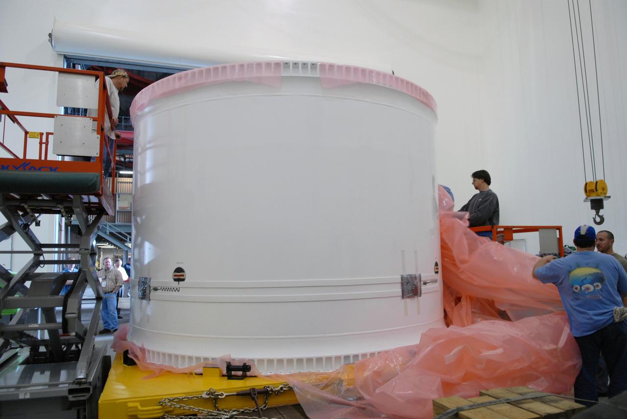 CAPE CANAVERAL, Fla. – In the extended duration orbiter lab, or EDO, of the Vehicle Assembly Building at NASA's Kennedy Space Center in Florida, workers remove the final plastic cover from the fifth segment simulator center. It will be prepared for stacking with other segments in the VAB. Ares I-X is the test vehicle for the Ares I, which is part of the Constellation Program to return men to the moon and beyond. Ares I is the essential core of a safe, reliable, cost-effective space transportation system that eventually will carry crewed missions back to the moon, on to Mars and out into the solar system. Ares I-X is targeted for launch in July 2009. Photo credit: NASA/Troy Cryder