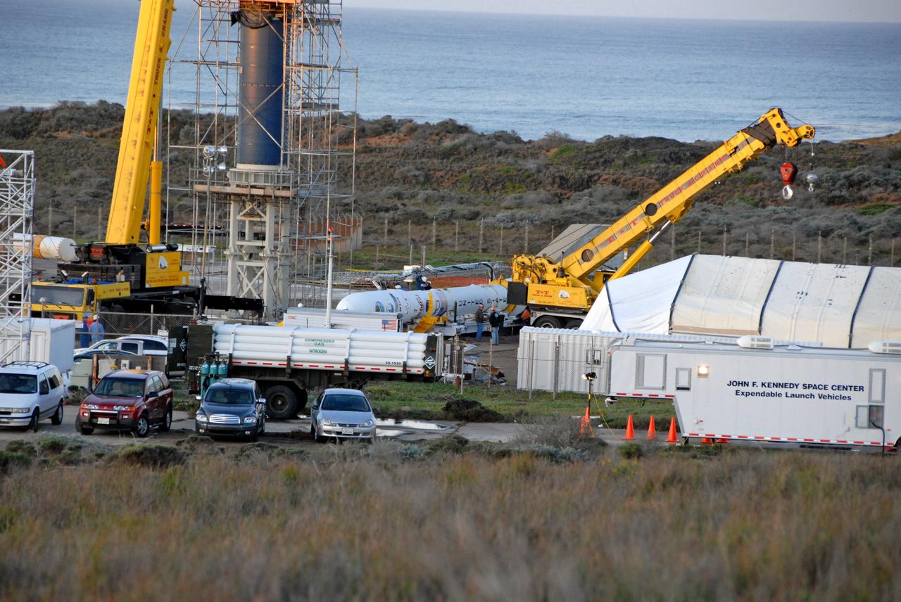 VANDENBERG AIR FORCE BASE, Calif. --  On Launch Complex 576-E at Vandenberg Air Force Base in California, NASA's Orbiting Carbon Observatory, or OCO, upper stack is prepared to be raised to vertical. The upper stack, consists of Stages 1, 2 and 3 of Orbital Sciences' Taurus XL rocket as well as the encapsulated OCO spacecraft. Once vertical, the upper stack will be lifted and attached to the Taurus Stage 0, at left. OCO is scheduled for launch aboard the Taurus Feb. 24 from Vandenberg. The spacecraft will collect precise global measurements of carbon dioxide (CO2) in the Earth's atmosphere. Scientists will analyze OCO data to improve our understanding of the natural processes and human activities that regulate the abundance and distribution of this important greenhouse gas. Photo credit: NASA/Dan Liberotti, VAFB