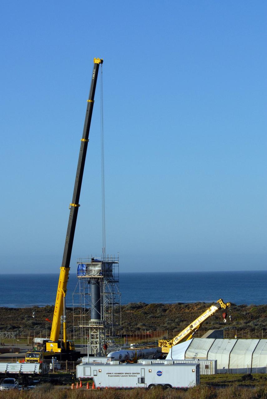 VANDENBERG AIR FORCE BASE, Calif. --  On Launch Complex 576-E at Vandenberg Air Force Base in California, the crane, at left, is attached to NASA's Orbiting Carbon Observatory, or OCO, upper stack to lift and attach the spacecraft to Orbital Sciences' Taurus XL rocket's Stage 0 (within the scaffolding). A portion of the umbilical tower (above it) is attached to the upper stack.  The upper stack consists of Stages 1, 2 and 3 of the Taurus as well as the encapsulated OCO spacecraft. OCO is scheduled for launch aboard the Taurus Feb. 24 from Vandenberg. The spacecraft will collect precise global measurements of carbon dioxide (CO2) in the Earth's atmosphere. Scientists will analyze OCO data to improve our understanding of the natural processes and human activities that regulate the abundance and distribution of this important greenhouse gas. Photo credit: NASA/Dan Liberotti, VAFB