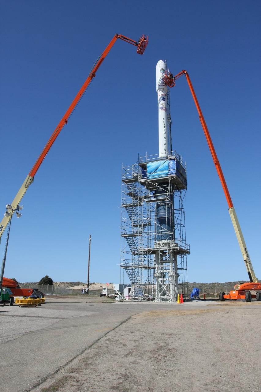 VANDENBERG AIR FORCE BASE, Calif. --  With the fairing door off, Orbital Sciences' Glenn Weigle and Brett Gladish take the GN2 flow reading on NASA's Orbiting Carbon Observatory, or OCO, spacecraft on Launch Complex 576-E at Vandenberg Air Force Base in California.  The encapsulated OCO tops Orbital Sciences' Taurus XL rocket, which is scheduled to launch Feb. 24. The spacecraft sits atop Orbital Sciences' Taurus XL rocket. At right is a portion of the umbilical tower attached to the upper stack.  The spacecraft sits atop Orbital Sciences' Taurus XL rocket. At right is a portion of the umbilical tower attached to the upper stack. The spacecraft will collect precise global measurements of carbon dioxide (CO2) in the Earth's atmosphere. Scientists will analyze OCO data to improve our understanding of the natural processes and human activities that regulate the abundance and distribution of this important greenhouse gas.  Photo courtesy of Jim Stowers, Orbital Sciences