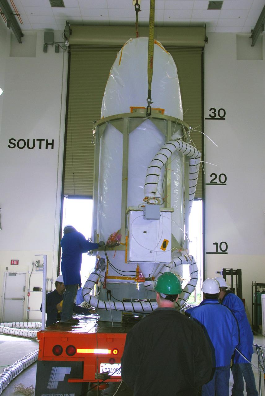 VANDENBERG AIR FORCE BASE, Calif. --  In the Astrotech payload processing facility at Vandenberg Air Force Base in California,  workers help guide NASA's Orbiting Carbon Observatory, or OCO, into place on a transporter.  The spacecraft will be moved to Launch Complex 576-E.  An umbilical line is attached. OCO will collect precise global measurements of carbon dioxide (CO2) in the Earth's atmosphere. Scientists will analyze OCO data to improve our understanding of the natural processes and human activities that regulate the abundance and distribution of this important greenhouse gas. OCO is scheduled to launch Feb. 24 aboard an Orbital Sciences' Taurus XL rocket.  Photo credit: NASA/VAFB