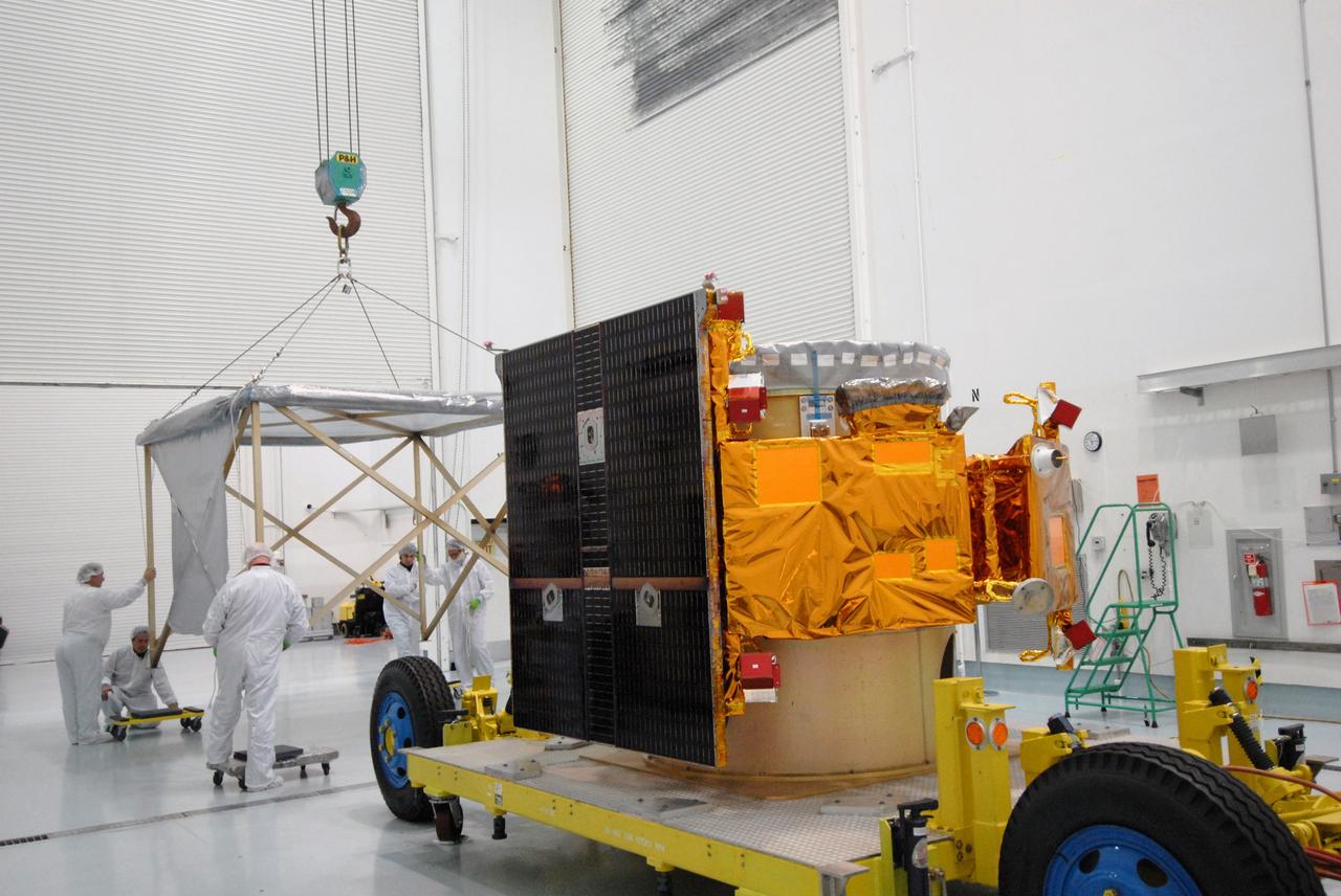 CAPE CANAVERAL, Fla. – At the Astrotech payload processing facility near NASA's Kennedy Space Center in Florida, workers at left guide the shipping cage removed from around NASA's Lunar CRater Observation and Sensing Satellite, known as LCROSS, at right. The satellite's primary mission is to search for water ice on the moon in a permanently shadowed crater near one of the lunar poles. LCROSS is a low-cost, accelerated-development, companion mission to NASA's Lunar Reconnaissance Orbiter, or LRO. At Kennedy, the two spacecraft will be integrated with an Atlas V launch vehicle and tested for final flight worthiness. LCROSS and LRO are the first missions in NASA's plan to return humans to the moon and begin establishing a lunar outpost by 2020. Launch is no earlier than April 24. Photo credit: NASA/Tim Jacobs