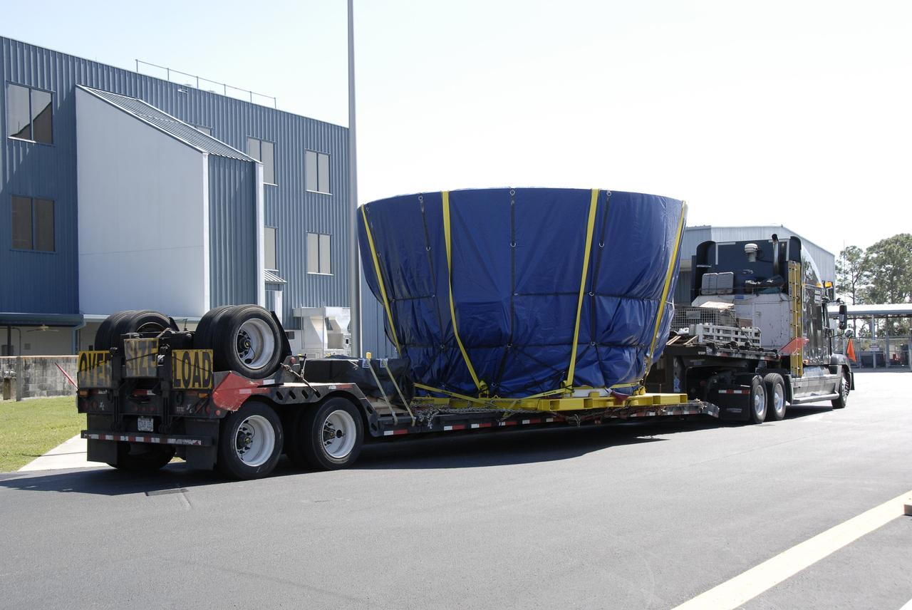 CAPE CANAVERAL, Fla. – The last newly manufactured section of the Ares I-X test rocket, the frustum, arrives at the Assembly and Refurbishment Facility of NASA's Kennedy Space Center.   Resembling a giant funnel, the frustum's function is to transition the primary flight loads from the rocket's upper stage to the first stage. The frustum is located between the forward skirt extension and the upper stage of the Ares I-X. Weighing in at approximately 13,000 pounds, the 10-foot-long section is composed of two aluminum rings attached to a truncated conic section. The large diameter of the cone is 18 feet and the small diameter is 12 feet. The cone is 1.25 inches thick. The frustum will be integrated with the forward skirt and forward skirt extension, which already are in the Assembly and Refurbishment Facility. That will complete the forward assembly. The assembly then will be moved to the Vehicle Assembly Building for stacking operations, which are scheduled to begin in April. Manufactured by Major Tool and Machine Inc. in Indiana under a subcontract with Alliant Techsystems Inc., or ATK, the Ares I-X is targeted to launch in the summer of 2009. The flight will provide NASA with an early opportunity to test and prove hardware, facilities and ground operations associated with the Ares I launch vehicle. The flight test also will bring NASA a step closer to its exploration goals of sending humans to the moon and destinations beyond.  Photo credit: NASA/Kim Shiflett