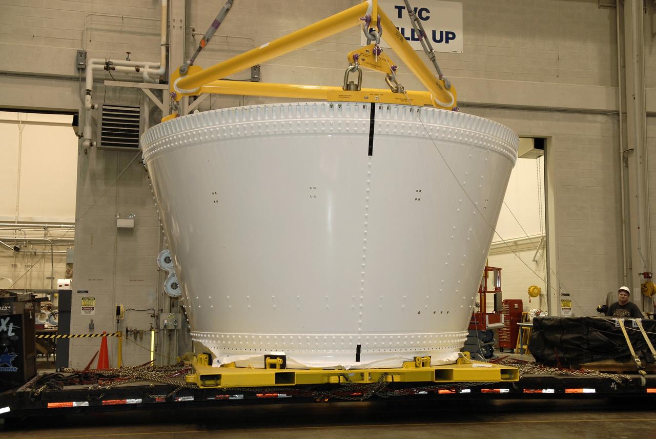 CAPE CANAVERAL, Fla. – In the Assembly and Refurbishment Facility, or ARF, at NASA's Kennedy Space Center, an overhead crane is attached to the frustum for the Ares I-X test rocket. The frustum is the last manufactured section of the Ares I-X. The frustum will be moved from the transporter to supports on the floor. Resembling a giant funnel, the frustum's function is to transition the primary flight loads from the rocket's upper stage to the first stage. The frustum is located between the forward skirt extension and the upper stage of the Ares I-X.  The frustum will be integrated with the forward skirt and forward skirt extension, which already are in the ARF. That will complete the forward assembly. The assembly then will be moved to the Vehicle Assembly Building for stacking operations, which are scheduled to begin in April.  Photo credit: NASA/Kim Shiflett