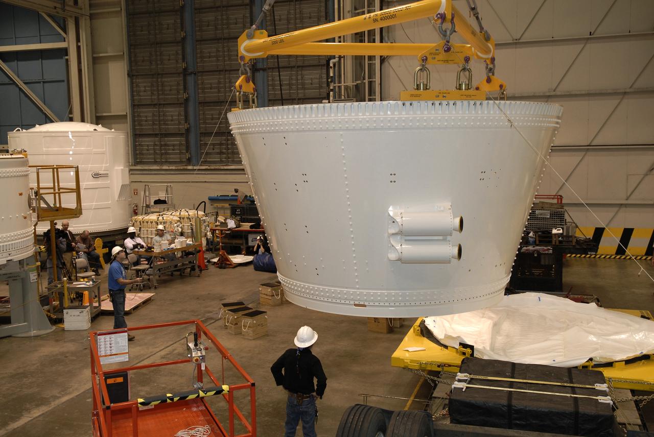 CAPE CANAVERAL, Fla. – In the Assembly and Refurbishment Facility, or ARF, at NASA's Kennedy Space Center, an overhead crane lifts the frustum for the Ares I-X test rocket from its transporter. The frustum is the last manufactured section of the Ares I-X. The frustum will be moved from the transporter to supports on the floor.  Resembling a giant funnel, the frustum's function is to transition the primary flight loads from the rocket's upper stage to the first stage. The frustum is located between the forward skirt extension and the upper stage of the Ares I-X.  The frustum will be integrated with the forward skirt and forward skirt extension, which already are in the ARF. That will complete the forward assembly. The assembly then will be moved to the Vehicle Assembly Building for stacking operations, which are scheduled to begin in April.  Photo credit: NASA/Kim Shiflett