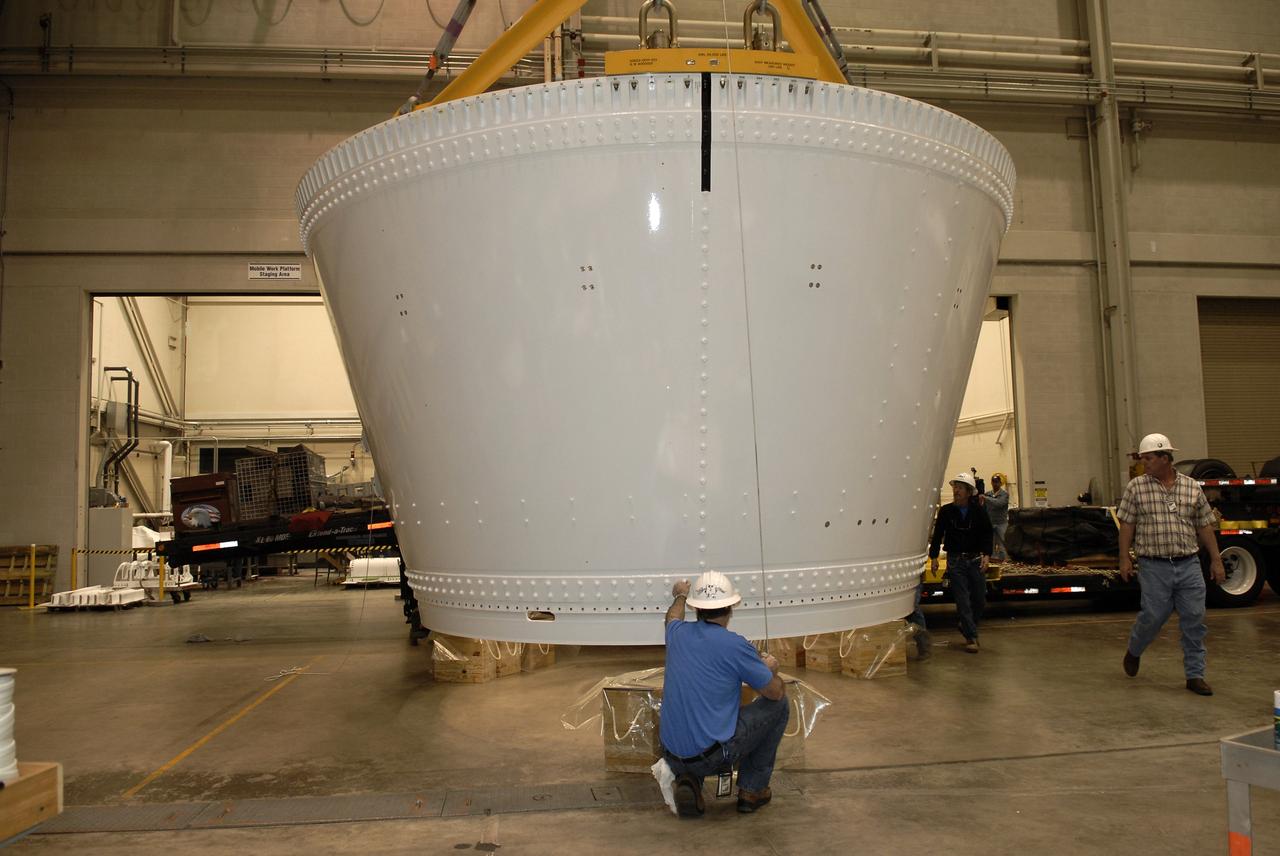 CAPE CANAVERAL, Fla. – In the Assembly and Refurbishment Facility, or ARF, at NASA's Kennedy Space Center, an overhead crane lowers the frustum for the Ares I-X test rocket onto supports on the floor. The frustum is the last manufactured section of the Ares I-X. Resembling a giant funnel, the frustum's function is to transition the primary flight loads from the rocket's upper stage to the first stage. The frustum is located between the forward skirt extension and the upper stage of the Ares I-X.  The frustum will be integrated with the forward skirt and forward skirt extension, which already are in the ARF. That will complete the forward assembly. The assembly then will be moved to the Vehicle Assembly Building for stacking operations, which are scheduled to begin in April.  Photo credit: NASA/Kim Shiflett