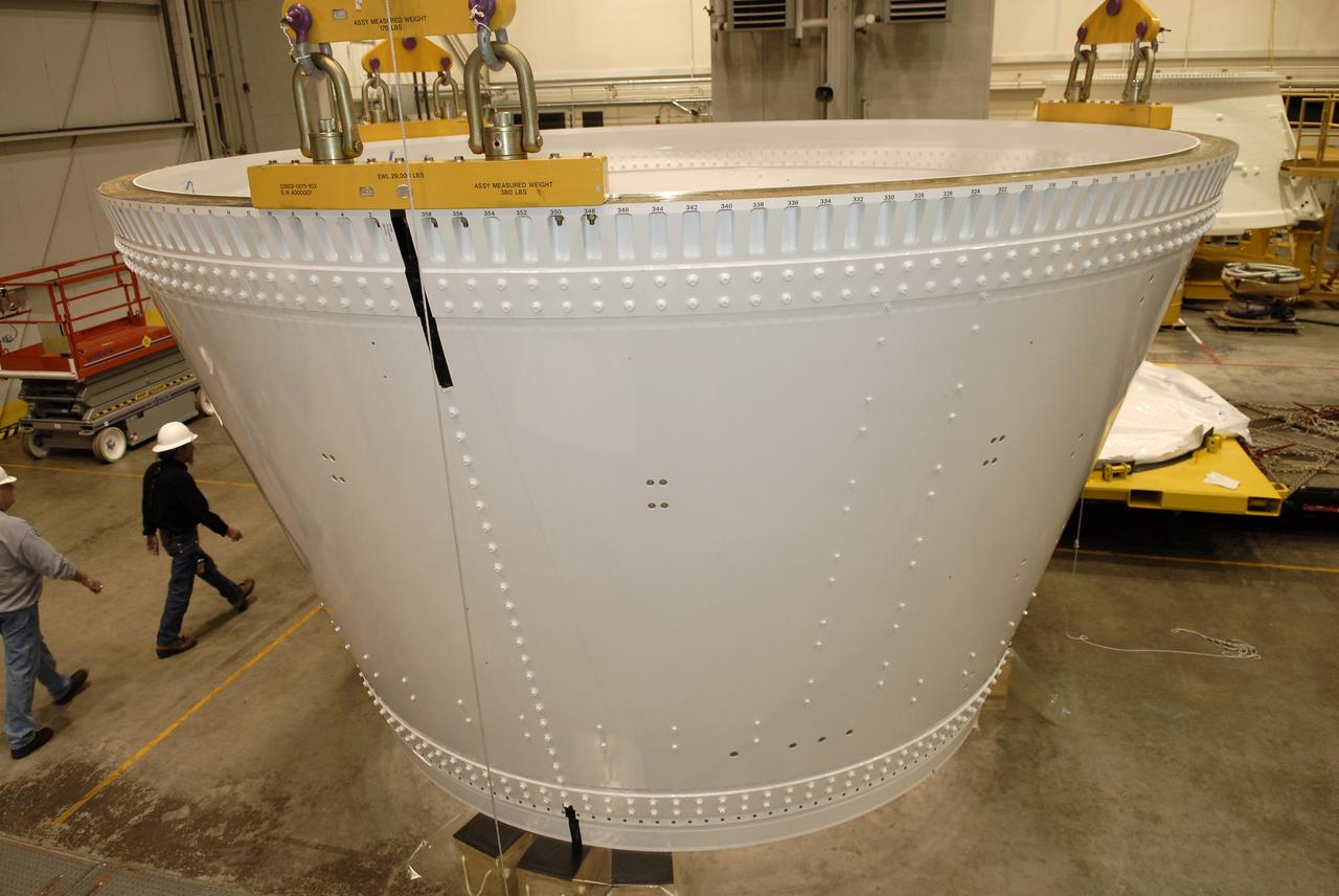 CAPE CANAVERAL, Fla. – In the Assembly and Refurbishment Facility, or ARF, at NASA's Kennedy Space Center, an overhead crane lowers the frustum for the Ares I-X test rocket onto supports on the floor. The frustum is the last manufactured section of the Ares I-X.  Resembling a giant funnel, the frustum's function is to transition the primary flight loads from the rocket's upper stage to the first stage. The frustum is located between the forward skirt extension and the upper stage of the Ares I-X.  The frustum will be integrated with the forward skirt and forward skirt extension, which already are in the ARF. That will complete the forward assembly. The assembly then will be moved to the Vehicle Assembly Building for stacking operations, which are scheduled to begin in April.  Photo credit: NASA/Kim Shiflett