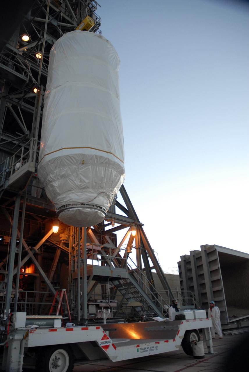 CAPE CANAVERAL, Fla. – Covered by a protective cover, NASA's Kepler spacecraft on Launch pad 17-B at Cape Canaveral Air Force Station in Florida is lifted alongside the mobile service tower. It will be moved into the tower for mating with the Delta II rocket for launch. The liftoff of Kepler is currently scheduled for 10:48 p.m. EST March 5. Kepler is designed to survey more than 100,000 stars in our galaxy to determine the number of sun-like stars that have Earth-size and larger planets, including those that lie in a star's "habitable zone," a region where liquid water, and perhaps life, could exist. If these Earth-size worlds do exist around stars like our sun, Kepler is expected to be the first to find them and the first to measure how common they are. Photo credit: NASA/Jack Pfaller
