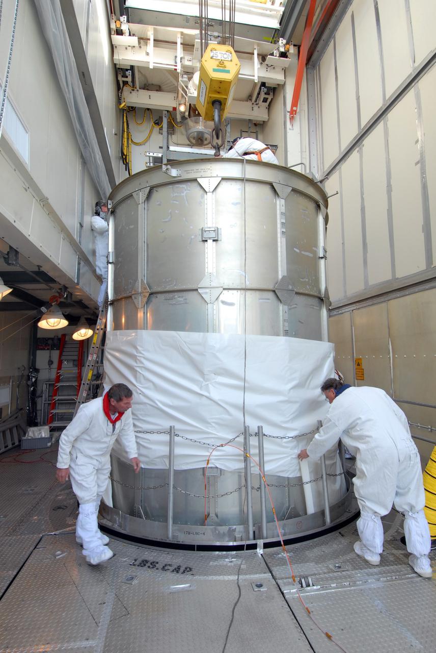 CAPE CANAVERAL, Fla. –  In the mobile service tower on Launch pad 17-B at Cape Canaveral Air Force Station in Florida, workers remove the protective cover from the metal transportation canister around NASA's Kepler spacecraft.  The spacecraft was mated with the Delta II rocket for launch. The liftoff of Kepler is currently scheduled for 10:48 p.m. EST March 5. Kepler is designed to survey more than 100,000 stars in our galaxy to determine the number of sun-like stars that have Earth-size and larger planets, including those that lie in a star's "habitable zone," a region where liquid water, and perhaps life, could exist. If these Earth-size worlds do exist around stars like our sun, Kepler is expected to be the first to find them and the first to measure how common they are.   Photo credit: NASA/Jack Pfaller