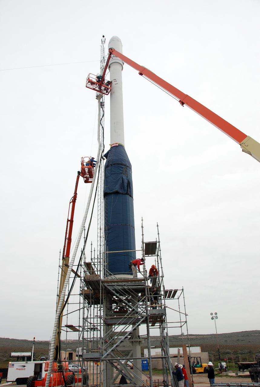 VANDENBERG AIR FORCE BASE, Calif. -- On Launch Complex 576-E at Vandenberg Air Force Base in California, workers remove the umbilical tower attached to Orbital Sciences' Taurus XL rocket.  Atop the rocket is NASA's Orbiting Carbon Observatory, or OCO, which is scheduled to launch Feb. 24 from Vandenberg. The spacecraft will collect precise global measurements of carbon dioxide (CO2) in the Earth's atmosphere. Scientists will analyze OCO data to improve our understanding of the natural processes and human activities that regulate the abundance and distribution of this important greenhouse gas.  Photo credit: NASA/Richard Nielsen, VAFB