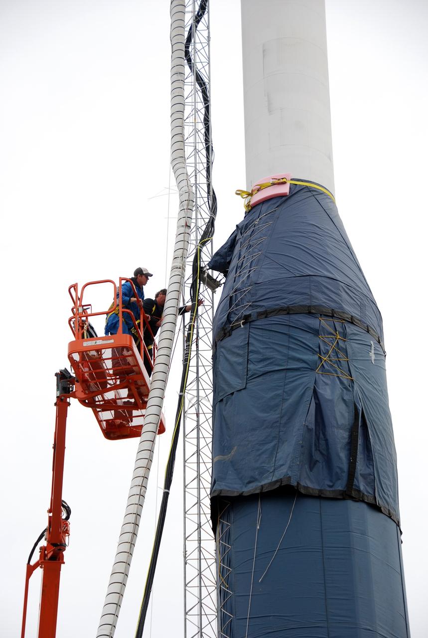 VANDENBERG AIR FORCE BASE, Calif. -- On Launch Complex 576-E at Vandenberg Air Force Base in California, workers remove the umbilical tower attached to Orbital Sciences' Taurus XL rocket.  Atop the rocket is NASA's Orbiting Carbon Observatory, or OCO, which is scheduled to launch Feb. 24 from Vandenberg. The spacecraft will collect precise global measurements of carbon dioxide (CO2) in the Earth's atmosphere. Scientists will analyze OCO data to improve our understanding of the natural processes and human activities that regulate the abundance and distribution of this important greenhouse gas.  Photo credit: NASA/Richard Nielsen, VAFB