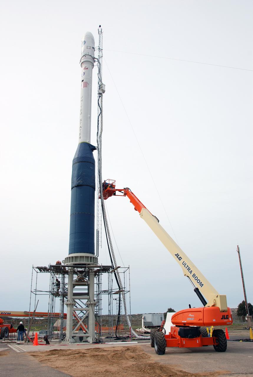 VANDENBERG AIR FORCE BASE, Calif. -- On Launch Complex 576-E at Vandenberg Air Force Base in California, workers remove the umbilical tower attached to Orbital Sciences' Taurus XL rocket.  Atop the rocket is NASA's Orbiting Carbon Observatory, or OCO, which is scheduled to launch Feb. 24 from Vandenberg. The spacecraft will collect precise global measurements of carbon dioxide (CO2) in the Earth's atmosphere. Scientists will analyze OCO data to improve our understanding of the natural processes and human activities that regulate the abundance and distribution of this important greenhouse gas.  Photo credit: NASA/Richard Nielsen, VAFB