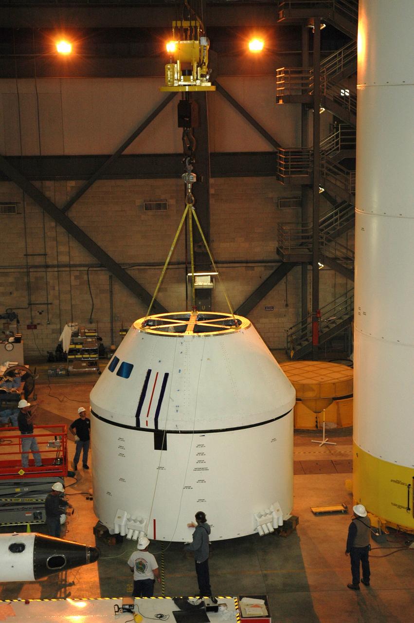 CAPE CANAVERAL, Fla. – In high bay 4 of the Vehicle Assembly Building at NASA's Kennedy Space Center in Florida, a crane removes the Ares I-X crew module simulator from the service module beneath.  Ares I-X is the test flight for the Ares I.   The I-X flight will provide NASA an early opportunity to test and prove hardware, facilities and ground operations associated with Ares I. The launch of the 327-foot-tall, full-scale Ares I-X, targeted for July 2009, will be the first in a series of unpiloted rocket launches from Kennedy. When fully developed, the 16-foot diameter crew module will furnish living space and reentry protection for the astronauts.  Photo credit: NASA/Tim Jacobs