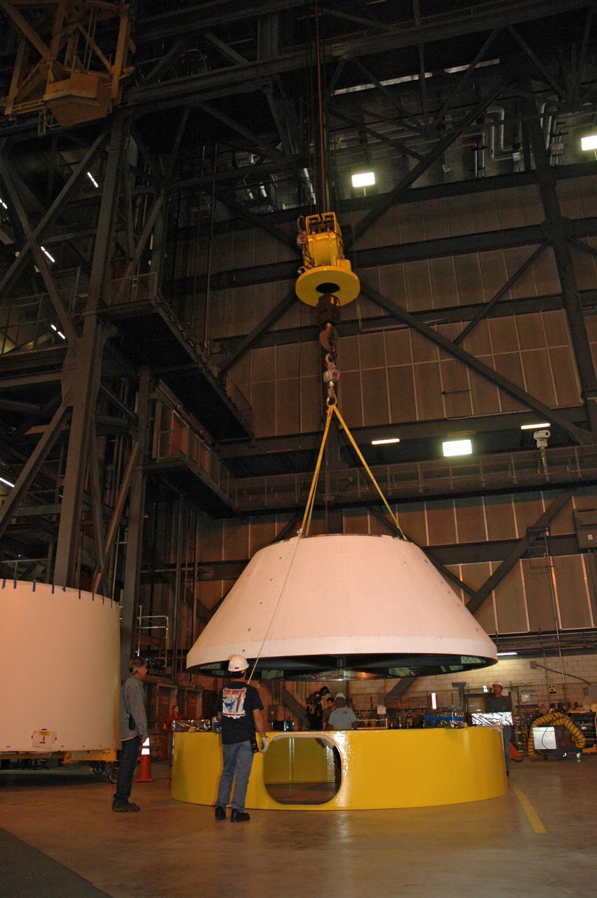 CAPE CANAVERAL, Fla. – In high bay 4 of the Vehicle Assembly Building at NASA's Kennedy Space Center in Florida, a crane lowers the Ares I-X crew module simulator toward a stand.  Ares I-X is the test flight for the Ares I.   The I-X flight will provide NASA an early opportunity to test and prove hardware, facilities and ground operations associated with Ares I. The launch of the 327-foot-tall, full-scale Ares I-X, targeted for July 2009, will be the first in a series of unpiloted rocket launches from Kennedy. When fully developed, the 16-foot diameter crew module will furnish living space and reentry protection for the astronauts.  Photo credit: NASA/Tim Jacobs
