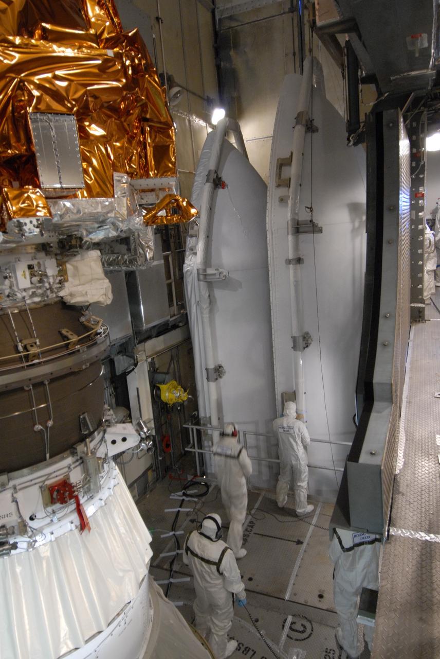 CAPE CANAVERAL, Fla. – On Launch Pad 17-B at Cape Canaveral Air Force Station in Florida, workers wait for the arrival of the two fairing components that will be installed around NASA's Kepler spacecraft, seen at left. The fairing is a molded structure that fits flush with the outside surface of the rocket and forms an aerodynamically smooth nose cone, protecting the spacecraft during launch and ascent. The liftoff of Kepler aboard the Delta II rocket is currently targeted for launch in a window extending 10:49 to 10:52 p.m. EST March 6 from Pad 17-B. Kepler is designed to survey more than 100,000 stars in our galaxy to determine the number of sun-like stars that have Earth-size and larger planets, including those that lie in a star's "habitable zone," a region where liquid water, and perhaps life, could exist. If these Earth-size worlds do exist around stars like our sun, Kepler is expected to be the first to find them and the first to measure how common they are.  Photo credit: NASA/Jack Pfaller