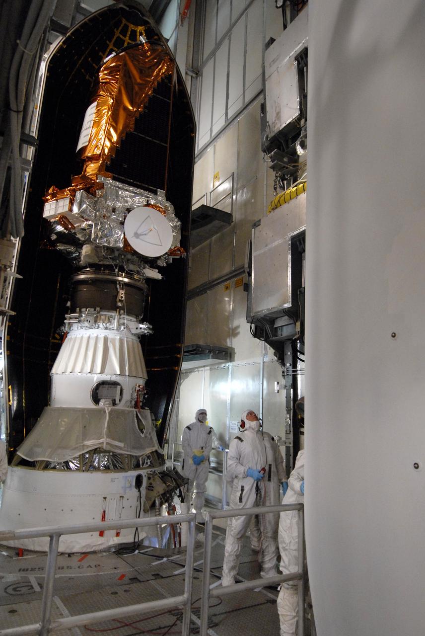 CAPE CANAVERAL, Fla. – On Launch Pad 17-B at Cape Canaveral Air Force Station in Florida, workers watch closely as the second half of the fairing is moved into the mobile service tower for placement around NASA's Kepler spacecraft (left) to complete encapsulation. The fairing is a molded structure that fits flush with the outside surface of the rocket and forms an aerodynamically smooth nose cone, protecting the spacecraft during launch and ascent. The liftoff of Kepler aboard the Delta II rocket is currently targeted for launch in a window extending 10:49 to 10:52 p.m. EST March 6 from Pad 17-B. Kepler is designed to survey more than 100,000 stars in our galaxy to determine the number of sun-like stars that have Earth-size and larger planets, including those that lie in a star's "habitable zone," a region where liquid water, and perhaps life, could exist. If these Earth-size worlds do exist around stars like our sun, Kepler is expected to be the first to find them and the first to measure how common they are.  Photo credit: NASA/Jack Pfaller