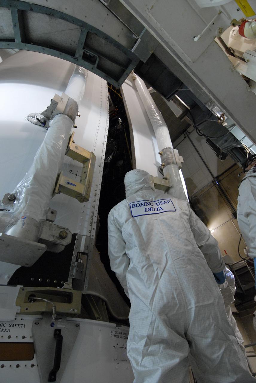 CAPE CANAVERAL, Fla. – On Launch Pad 17-B at Cape Canaveral Air Force Station in Florida, the second half of the fairing moves closer to the first half around NASA's Kepler spacecraft for encapsulation. The fairing is a molded structure that fits flush with the outside surface of the rocket and forms an aerodynamically smooth nose cone, protecting the spacecraft during launch and ascent. The liftoff of Kepler aboard the Delta II rocket is currently targeted for launch in a window extending 10:49 to 10:52 p.m. EST March 6 from Pad 17-B. Kepler is designed to survey more than 100,000 stars in our galaxy to determine the number of sun-like stars that have Earth-size and larger planets, including those that lie in a star's "habitable zone," a region where liquid water, and perhaps life, could exist. If these Earth-size worlds do exist around stars like our sun, Kepler is expected to be the first to find them and the first to measure how common they are.  Photo credit: NASA/Jack Pfaller