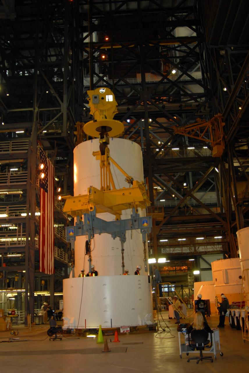 CAPE CANAVERAL, Fla. – In high bay 4 of the Vehicle Assembly Building at NASA's Kennedy Space Center in Florida, workers attach a large overhead crane to the Ares I-X service module, on the floor.  The module will be lifted and mated to the service adapter.  Ares I-X is the test flight for the Ares I. The I-X flight will provide NASA an early opportunity to test and prove hardware, facilities and ground operations associated with Ares I. The launch of the 327-foot-tall, full-scale Ares I-X, targeted for July 2009, will be the first in a series of unpiloted rocket launches from Kennedy. Photo credit: NASA/Tim Jacobs