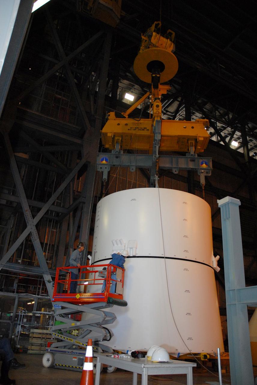 CAPE CANAVERAL, Fla. – In high bay 4 of the Vehicle Assembly Building at NASA's Kennedy Space Center in Florida, a large overhead crane lowers the Ares I-X service module onto the service adapter.  Workers check the precision of the connection. Ares I-X is the test flight for the Ares I. The I-X flight will provide NASA an early opportunity to test and prove hardware, facilities and ground operations associated with Ares I. The launch of the 327-foot-tall, full-scale Ares I-X, targeted for July 2009, will be the first in a series of unpiloted rocket launches from Kennedy. Photo credit: NASA/Tim Jacobs