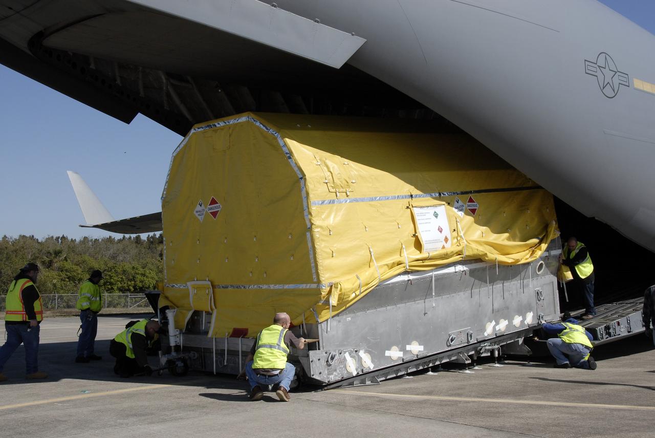 CAPE CANAVERAL, Fla. – At the Shuttle Landing Facility at NASA's Kennedy Space Center in Florida, workers check the latest Geostationary Operational Environmental Satellite, or GOES, as it moves out of the C-17 military cargo aircraft. Developed by NASA for the National Oceanic and Atmospheric Administration, or NOAA, the GOES-O satellite is targeted to launch April 28 onboard a United Launch Alliance Delta IV expendable launch vehicle. Once in orbit, GOES-O will be designated GOES-14, and NASA will provide on-orbit checkout and then transfer operational responsibility to NOAA. GOES-O will be placed in on-orbit storage as a replacement for an older GOES satellite. After arriving, the satellite was transported to Astrotech in Titusville, Fla., where final testing of the imaging system, instrumentation, communications and power systems will be performed. Photo credit: NASA/Kim Shiflett