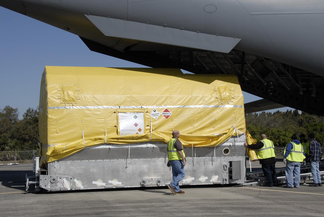 CAPE CANAVERAL, Fla. – At the Shuttle Landing Facility at NASA's Kennedy Space Center in Florida, workers  check the latest Geostationary Operational Environmental Satellite, or GOES, as it moves out of the C-17 military cargo aircraft. Developed by NASA for the National Oceanic and Atmospheric Administration, or NOAA, the GOES-O satellite is targeted to launch April 28 onboard a United Launch Alliance Delta IV expendable launch vehicle. Once in orbit, GOES-O will be designated GOES-14, and NASA will provide on-orbit checkout and then transfer operational responsibility to NOAA. GOES-O will be placed in on-orbit storage as a replacement for an older GOES satellite.  After arriving, the satellite was transported to Astrotech in Titusville, Fla., where final testing of the imaging system, instrumentation, communications and power systems will be performed. Photo credit: NASA/Kim Shiflett