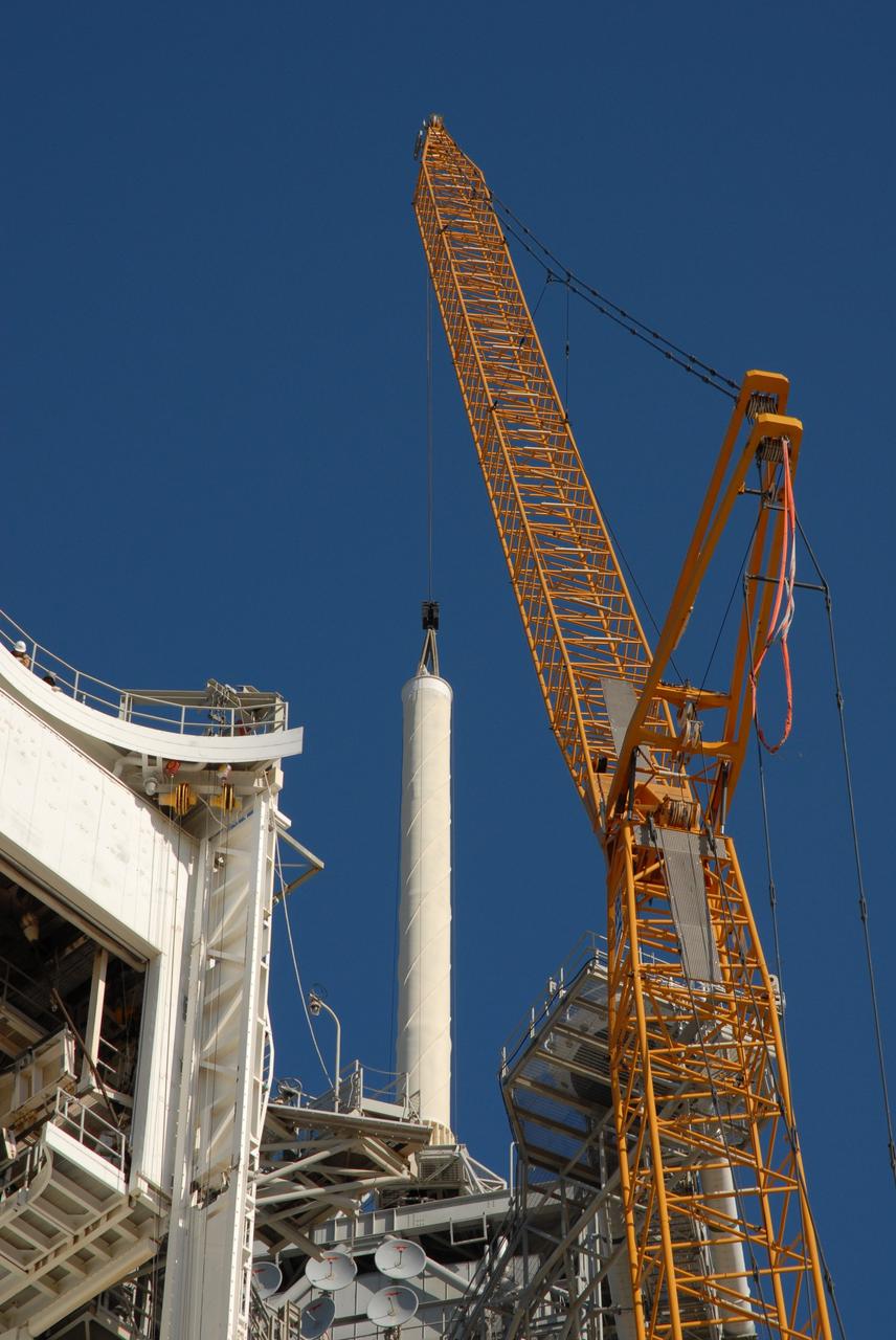 CAPE CANAVERAL, Fla. – On Launch Pad 39B at NASA's Kennedy Space Center in Florida, a crane is being used to remove the 80-foot lightning mast from the top of the fixed service structure.  The mast is no longer needed with the erection of the three lightning towers around the pad.  Pad 39B will be the site of the first Ares vehicle launch, including the Ares I-X test flight that is targeted for July 2009.  The three new lightning towers are 500 feet tall with an additional 100-foot fiberglass mast atop supporting a wire catenary system.  This improved lightning protection system allows for the taller height of the Ares I rocket compared to the space shuttle.  Photo credit: NASA/Amanda Diller