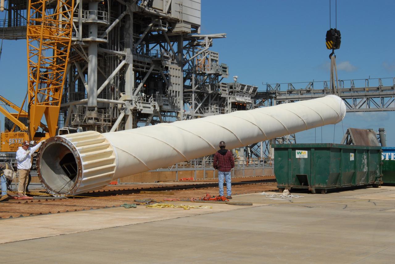 CAPE CANAVERAL, Fla. – On Launch Pad 39B at NASA's Kennedy Space Center in Florida, the 80-foot lightning mast removed from the top of the fixed service structure (behind it) is lowered onto the pad surface. The mast is no longer needed with the erection of the three lightning towers around the pad.  Pad 39B will be the site of the first Ares vehicle launch, including the Ares I-X test flight that is targeted for July 2009.  The three new lightning towers are 500 feet tall with an additional 100-foot fiberglass mast atop supporting a wire catenary system.  This improved lightning protection system allows for the taller height of the Ares I rocket compared to the space shuttle.  Photo credit: NASA/Amanda Diller