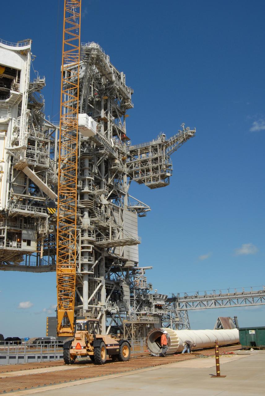 CAPE CANAVERAL, Fla. – On Launch Pad 39B at NASA's Kennedy Space Center in Florida, the 80-foot lightning mast removed from the top of the fixed service structure (center) rests on the pad surface. The mast is no longer needed with the erection of the three lightning towers around the pad.  Pad 39B will be the site of the first Ares vehicle launch, including the Ares I-X test flight that is targeted for July 2009.  The three new lightning towers are 500 feet tall with an additional 100-foot fiberglass mast atop supporting a wire catenary system.  This improved lightning protection system allows for the taller height of the Ares I rocket compared to the space shuttle.  Photo credit: NASA/Amanda Diller