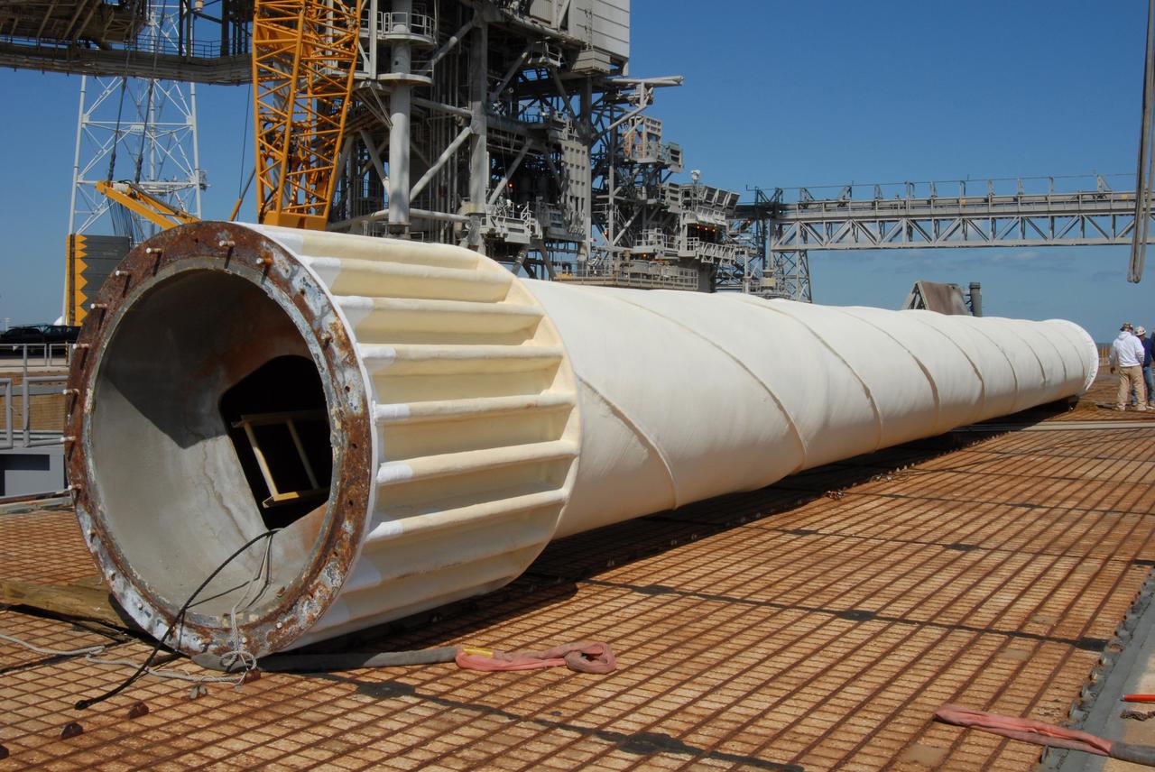 CAPE CANAVERAL, Fla. – On Launch Pad 39B at NASA's Kennedy Space Center in Florida, the 80-foot lightning mast removed from the top of the fixed service structure (left) rests on the pad surface. The mast is no longer needed with the erection of the three lightning towers around the pad.  Pad 39B will be the site of the first Ares vehicle launch, including the Ares I-X test flight that is targeted for July 2009.  The three new lightning towers are 500 feet tall with an additional 100-foot fiberglass mast atop supporting a wire catenary system.  This improved lightning protection system allows for the taller height of the Ares I rocket compared to the space shuttle.  Photo credit: NASA/Amanda Diller