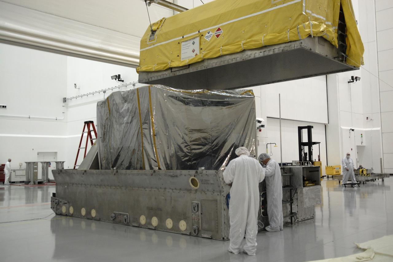 CAPE CANAVERAL, Fla. – In the Astrotech payload processing facility in Titusville, Fla., the top of the shipping container is moved away from the Geostationary Operational Environmental Satellite, or GOES-O, wrapped in a protective cover. The satellite will undergo final testing of the imaging system, instrumentation, communications and power systems.  Developed by NASA for the National Oceanic and Atmospheric Administration, or NOAA, the GOES-O satellite is targeted to launch April 28 onboard a United Launch Alliance Delta IV expendable launch vehicle.  Once in orbit, GOES-O will be designated GOES-14, and NASA will provide on-orbit checkout and then transfer operational responsibility to NOAA.  GOES-O will be placed in on-orbit storage as a replacement for an older GOES satellite.  Photo credit: NASA/Kim Shiflett